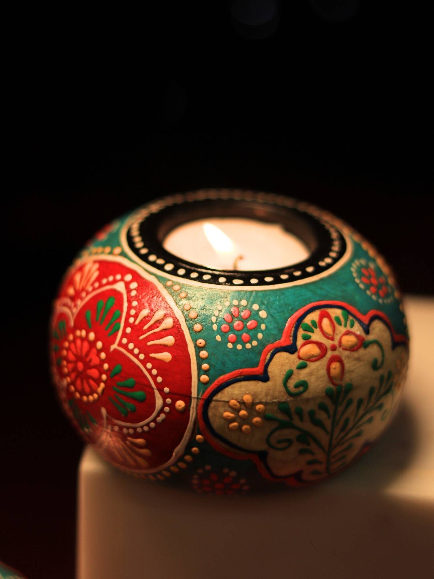 A handpainted wooden tealight holder, a perfect piece to hold a tealight and to add a colour pop to the decor.