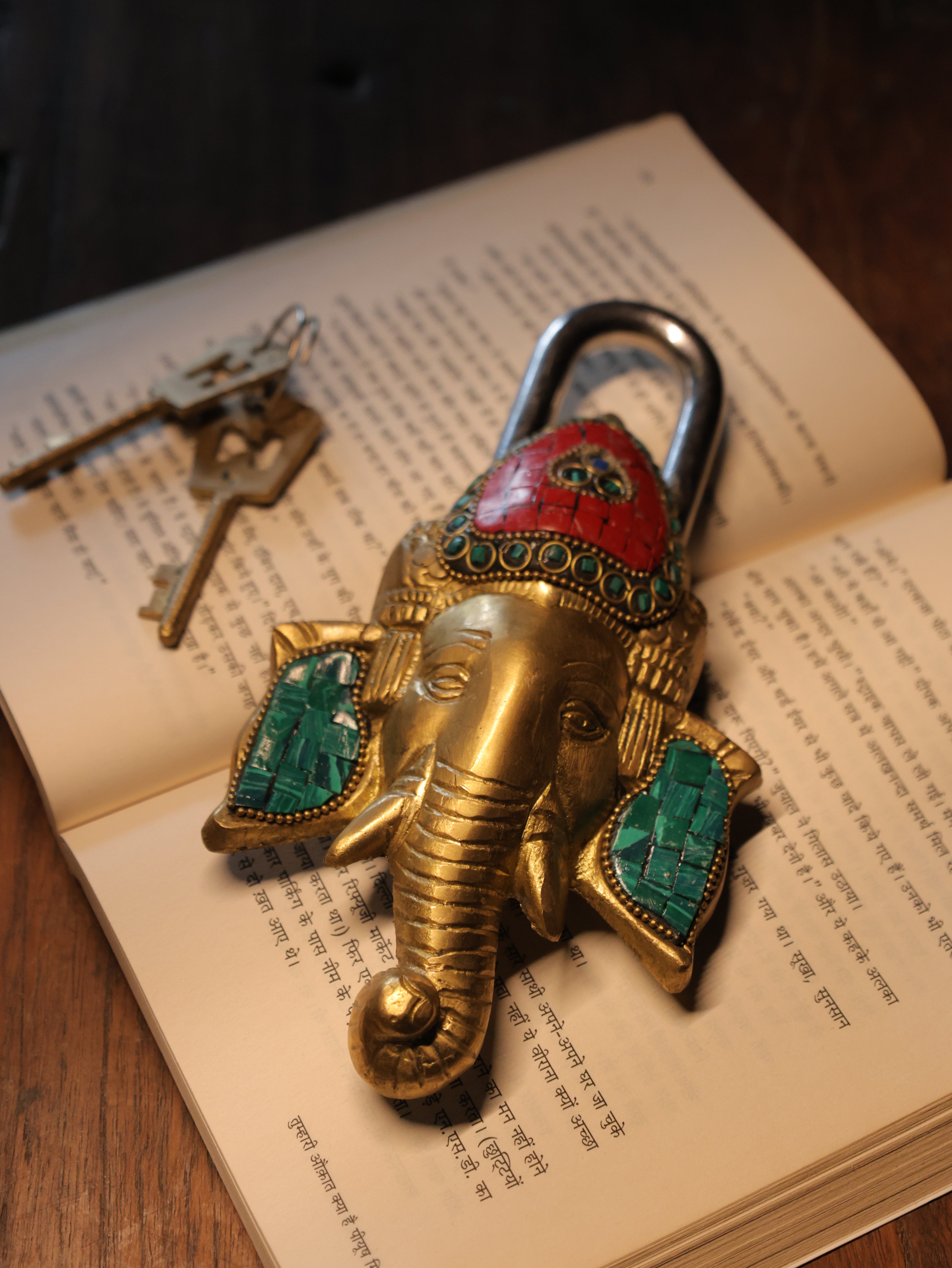 Decorative elephant lock with colored stones on an open book