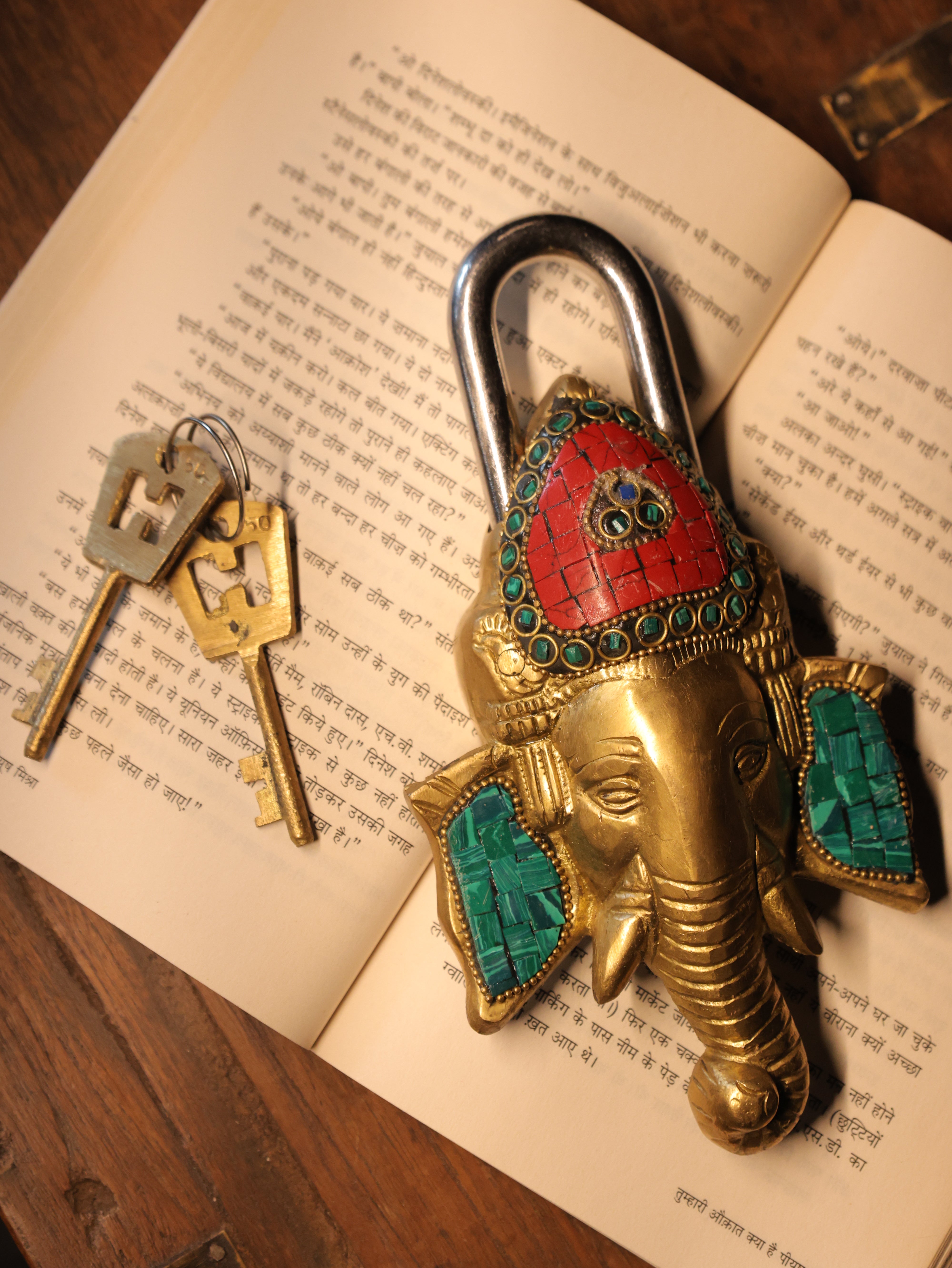 Decorative elephant-shaped padlock with turquoise and red accents on an open book.