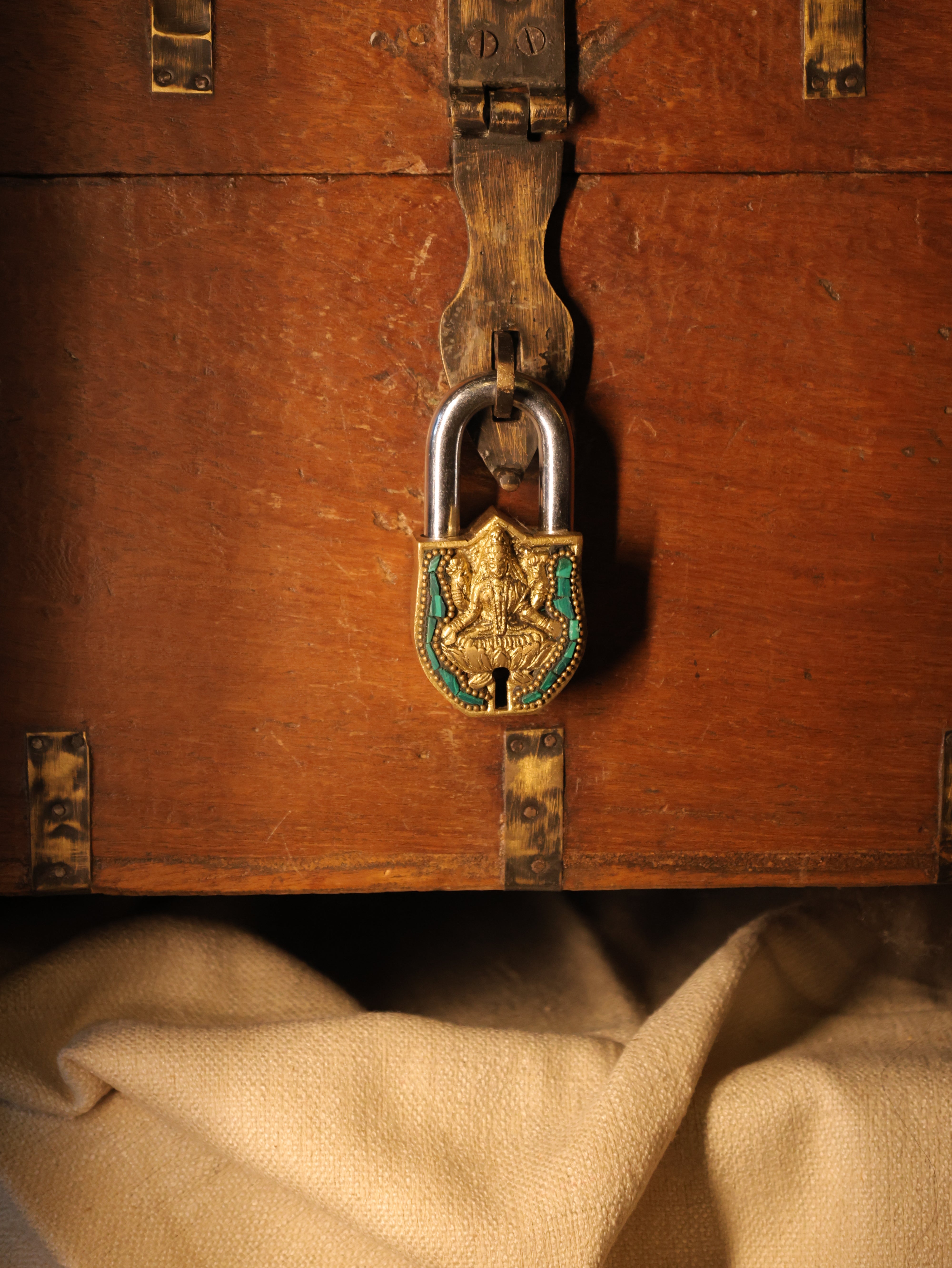 Close-up of a wooden chest with a decorative lock and keyhole.