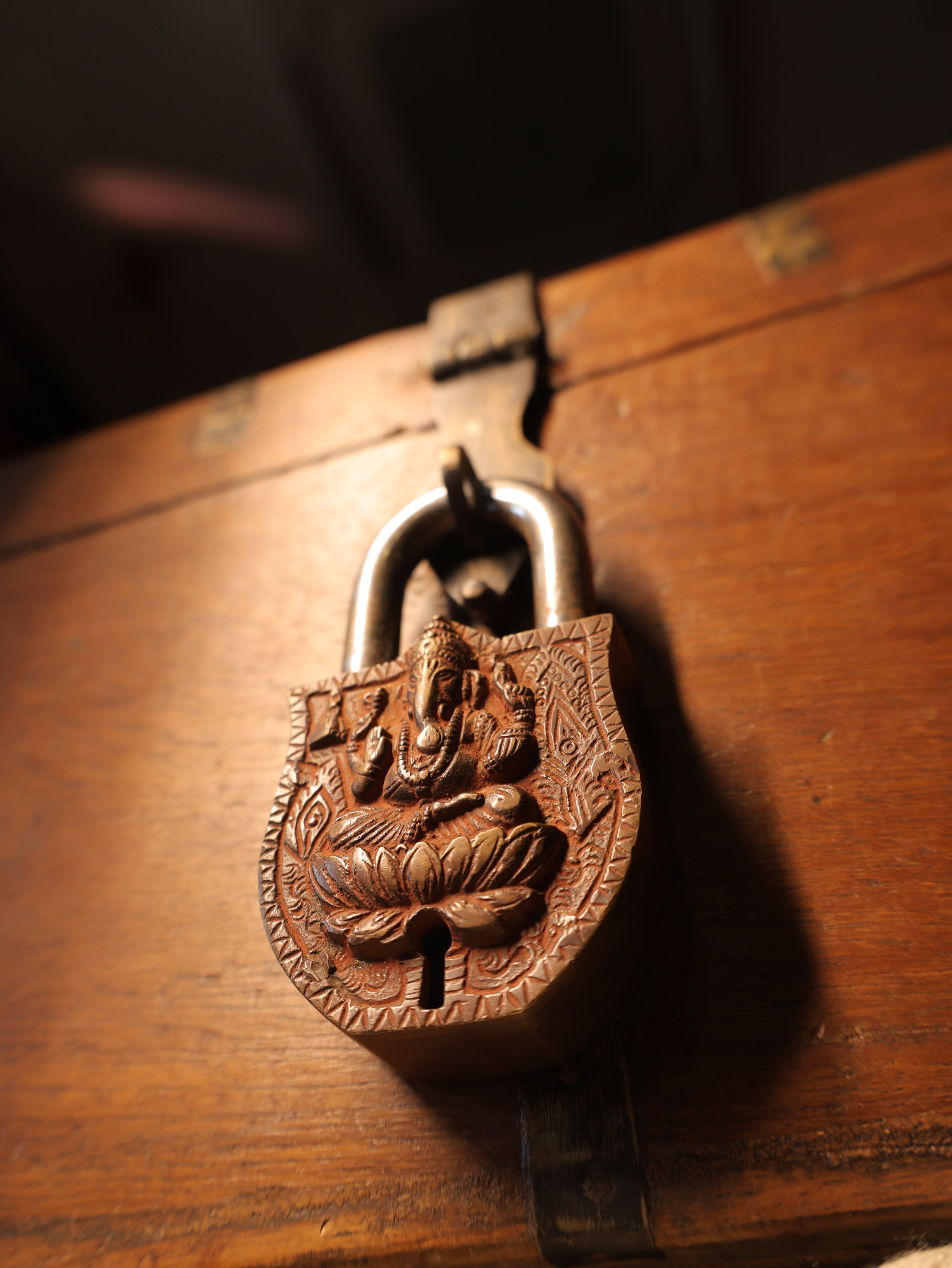 Decorative metal lock with intricate design on a wooden surface