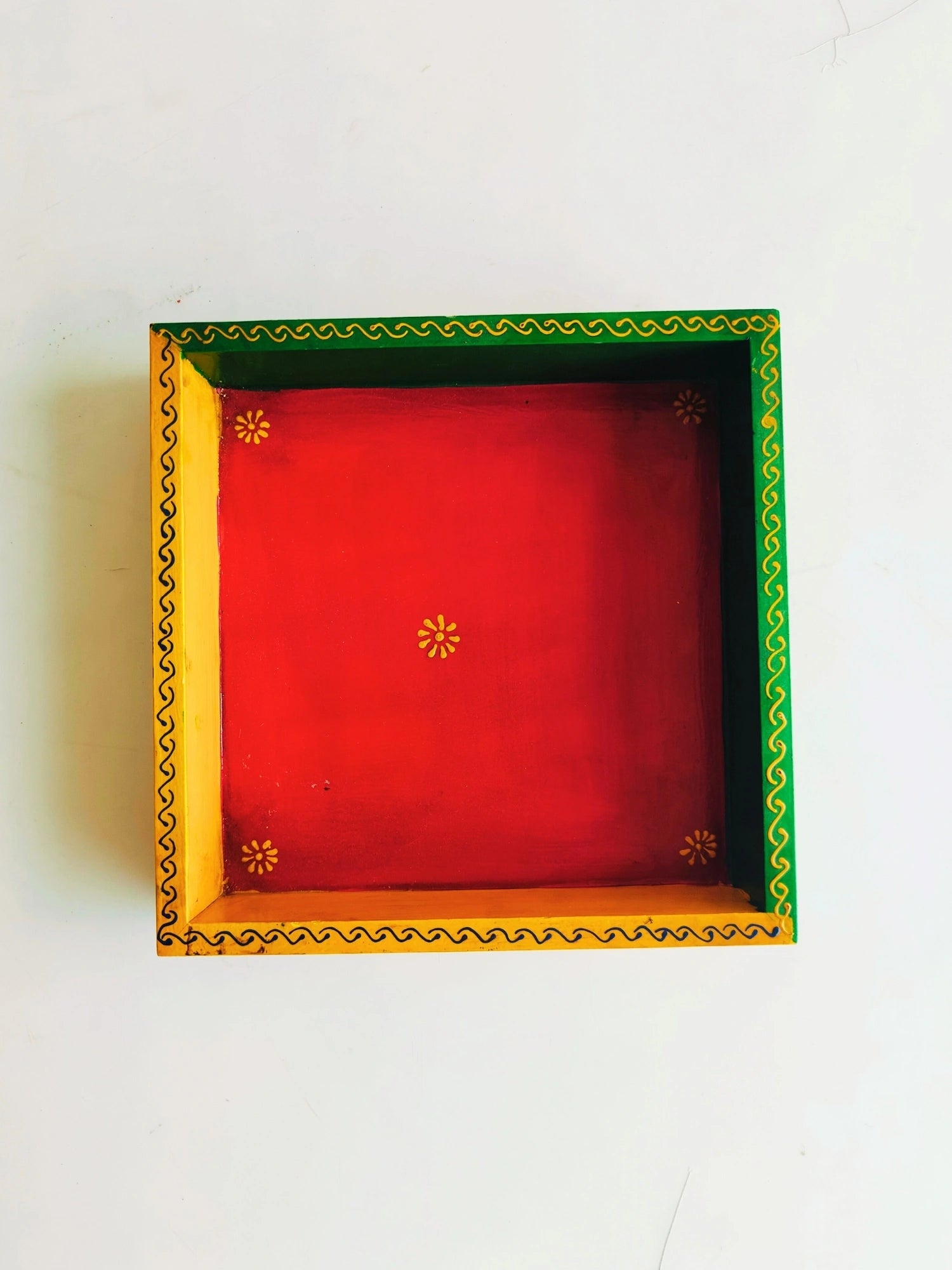 A handpainted wooden serving platter with four colored buckets on a white background, the platter and buckets have traditional floral and geometric patterns.
