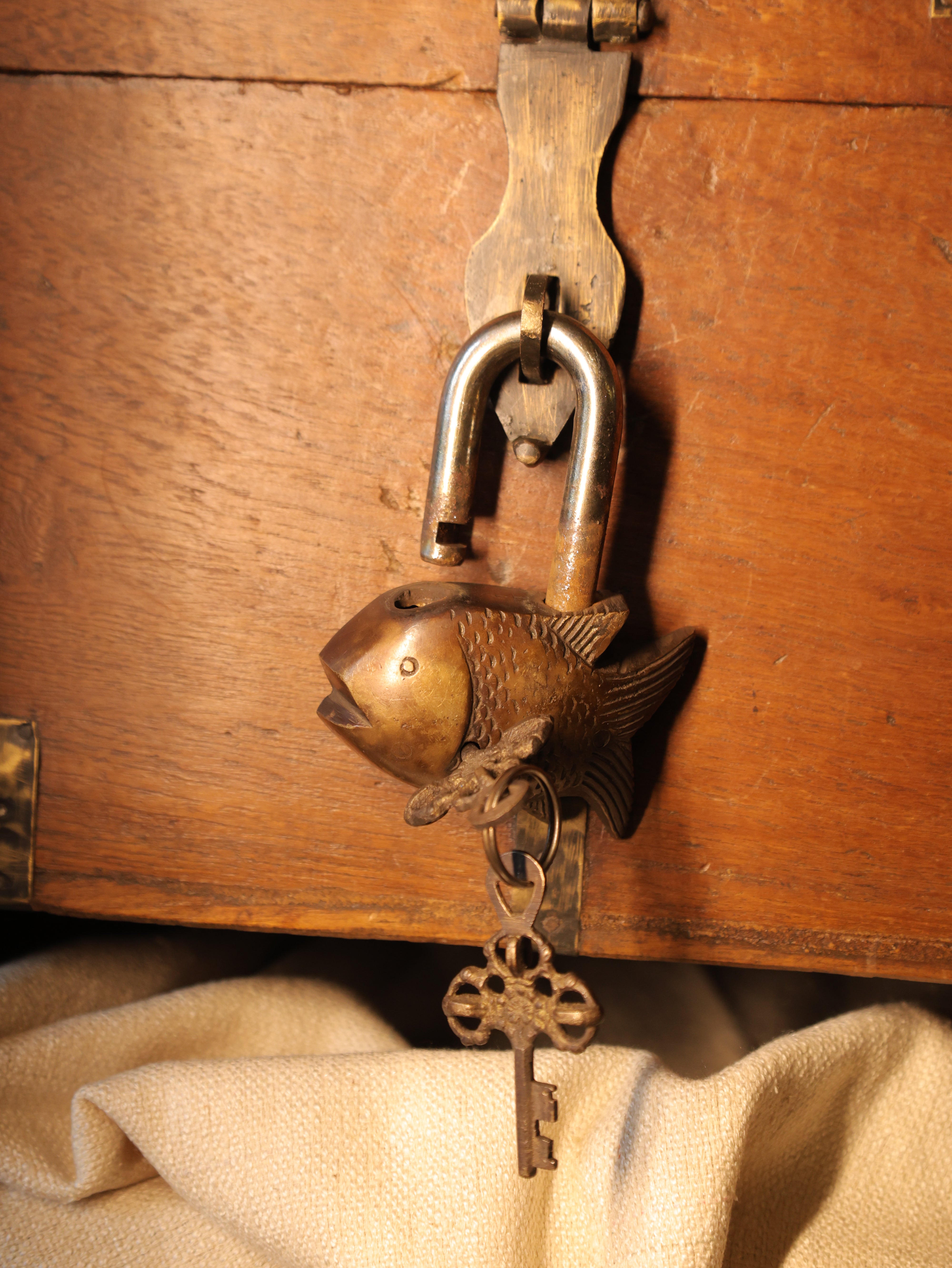 Brass padlock with decorative key on a wooden surface